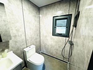 a bathroom with a toilet and a sink and a window at 箱根コンテナステイ コンビニすぐ 海賊船に乗ろう in Hakone