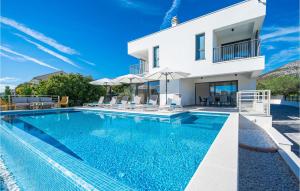 une villa avec piscine devant une maison dans l'établissement Beautiful Home In Seget Vranjica, à Seget Vranjica