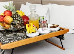 a tray of fruit and juice on a bed at Vivendas Hotel in Erechim