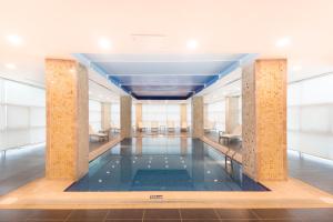 a pool in the middle of a building with windows at Park Dedeman Elazığ in Elazığ