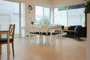 a dining room with a table and chairs and a couch at ResT Bangkok Poshtel in Bangkok