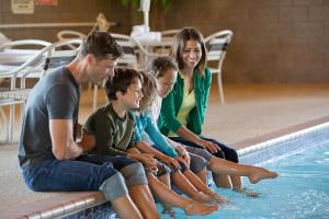 una familia sentada junto a una piscina en AmericInn by Wyndham Blackduck en Blackduck