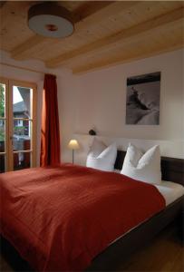 a bedroom with a large bed with a red blanket at Landgut Moralthof in Lenggries