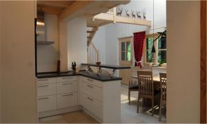 a kitchen with white cabinets and a dining room at Landgut Moralthof in Lenggries