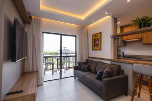 a living room with a couch and a balcony at Milos Comfort Club in Piçarras