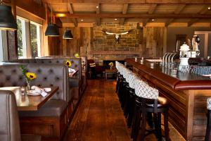 a restaurant with a long bar with leather chairs at Temecula Creek Inn in Temecula