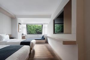 a hotel room with two beds and two windows at Walling Hotel - Chongqing Jiefangbei Hongyadong in Chongqing