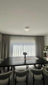 una sala da pranzo con tavolo, sedie e una finestra di Room in Melbourne Manor Lakes a Wyndham Vale