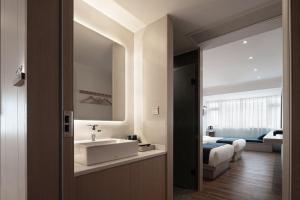 a bathroom with a sink and a bedroom with a bed at Walling Hotel - Chongqing Jiefangbei Hongyadong in Chongqing +34 photos
