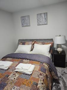 a bedroom with a bed with two towels on it at Contemporary Two Bedroom Basement Suite in Edmonton