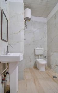 a white bathroom with a sink and a toilet at Haveli Palace - 2BHK Luxury Apartment in Udaipur +36 photos
