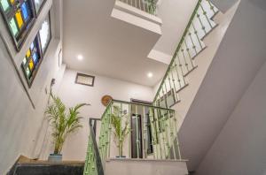 a staircase with green railings and potted plants at Haveli Palace - 2BHK Luxury Apartment in Udaipur