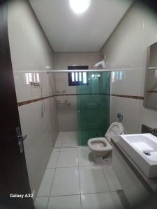 a bathroom with a shower and a toilet and a sink at Casa de pedra in Arroio do Silva