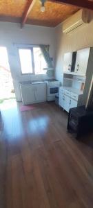 a kitchen with white appliances and a wooden floor at Cabaña el Roble in Lago Ranco