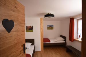ein kleines Schlafzimmer mit einem Bett mit einem Herz an der Wand in der Unterkunft Landgut Moralthof in Lenggries