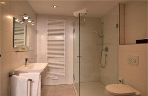 uma casa de banho com um chuveiro, um lavatório e um WC. em Landgut Moralthof em Lenggries