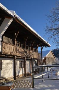 een groot houten gebouw in de sneeuw bij Landgut Moralthof in Lenggries