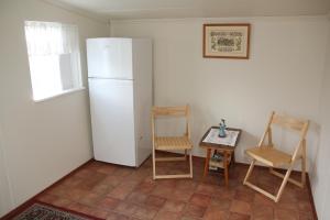 cocina con 2 sillas y nevera blanca en Hofdi Guesthouse en Húsavík