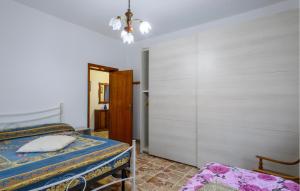 a bedroom with a bed and a chandelier at Awesome Apartment In Alba Adriatica in Alba Adriatica