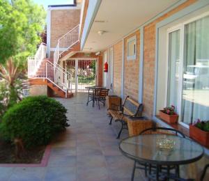 an outdoor patio with tables and chairs and stairs at Hotel Costa Limay in Plottier