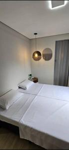 a large white bed in a white bedroom at Vila Caiçara Apê a 40m da Praia in Solemar