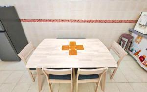 a white table with chairs and a cross on it at GOLDEN HOUSE ,1min to aeon, 7min to zoo,8min to lake gardens in Taiping