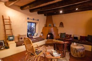 a living room with a couch and a fireplace at Adobe and Pines Inn Bed and Breakfast in Taos