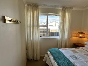 a bedroom with a bed and a window at Secrets 3 in Jeffreys Bay