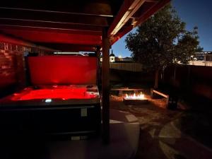 奥德萨HotTub-King Bed -Fire pit-BBQ-Pristine Kitchen的后院里一张红色的床，旁边有个火坑。