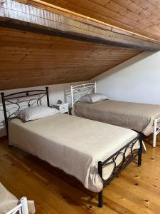 two beds in a room with wooden ceilings at Village Guest House in Corfu +21 photos