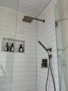 a bathroom with a shower with bottles on the wall at HotTub-King Bed -Fire pit-BBQ-Pristine Kitchen in Odessa +31 photos