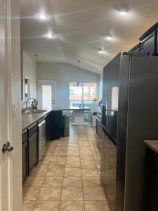 a kitchen with a refrigerator and a tile floor at HotTub-King Bed -Fire pit-BBQ-Pristine Kitchen in Odessa