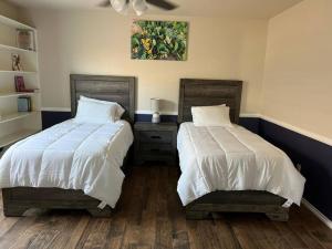 two beds sitting next to each other in a bedroom at HotTub-King Bed -Fire pit-BBQ-Pristine Kitchen in Odessa