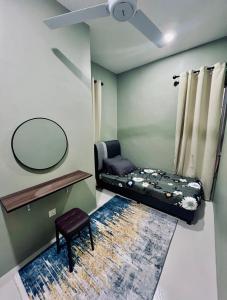 RR Homestay Yong Peng في Yong Peng: غرفة بسرير ومرآة ومقعد