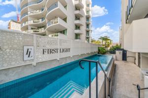 穆卢拉巴First Light Mooloolaba 9th floor apartment with ocean views的一座带公寓的大楼前的游泳池