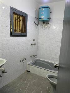 een badkamer met een bad, een toilet en een raam bij 3bhk villa at koramangala in Bangalore