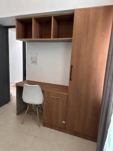 een bureau met een witte stoel naast een houten kast bij 3bhk villa at koramangala in Bangalore +11 foto's
