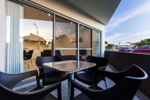 a table and chairs on the balcony of a house at Reflections By Rockingham Apartments in Rockingham