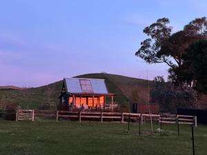 ein Haus mit Sonnenkollektor auf einem Feld in der Unterkunft Rustic country Cottage in Haumoana + 7 Fotos