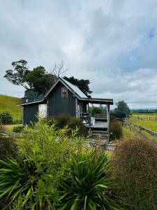 eine kleine Hütte in der Mitte eines Feldes in der Unterkunft Rustic country Cottage in Haumoana