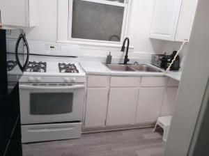 ルイスビルにあるPrivate Room Near to Downtown Churchill Downs UofL Airport &Kentucky Expo Centerのコンロとシンクのある白いキッチン