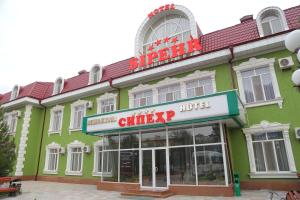 ein grünes Gebäude mit einem Schild für ein beklopptes Hotel in der Unterkunft Sipehr Hotel in Chkalovsk