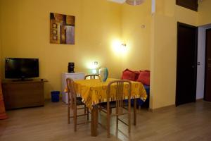 - une salle à manger avec une table, des chaises et un lit dans l'établissement Abba De Mar, à Alghero