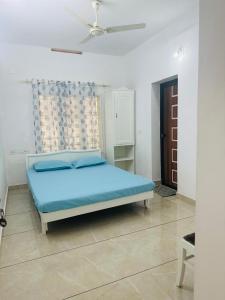 a bedroom with a blue bed in a white room at White House Homestay in Cochin +11 photos