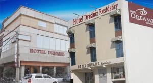 a building with a car parked in front of it at Hotel Dreamz Residency in Karnāl