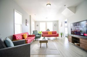 a living room with red couches and a flat screen tv at Near NYC Spacious 4 bedroom 2 and a half bath in North Bergen