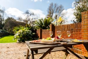 a picnic table with wine glasses and food on it at The Summerhouse in Milford on Sea