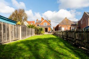 a fence in front of a yard with houses at The Summerhouse in Milford on Sea