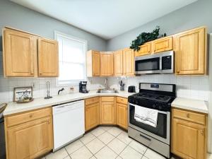 a kitchen with white appliances and wooden cabinets at 3 bed 1 bath FREE parking near NYC in North Bergen +15 photos