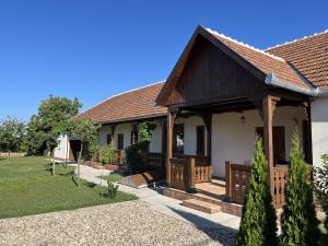 a house with a porch and a yard at Engstliz Apartman in Foeni